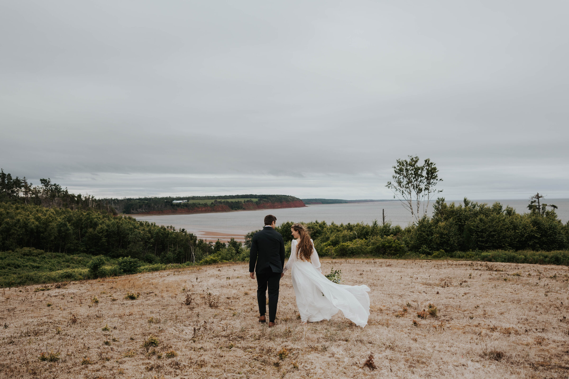 Levi and his wife Katelyn on the red cliffs near Orwell Cove, Prince Edward Island, looking out over the water